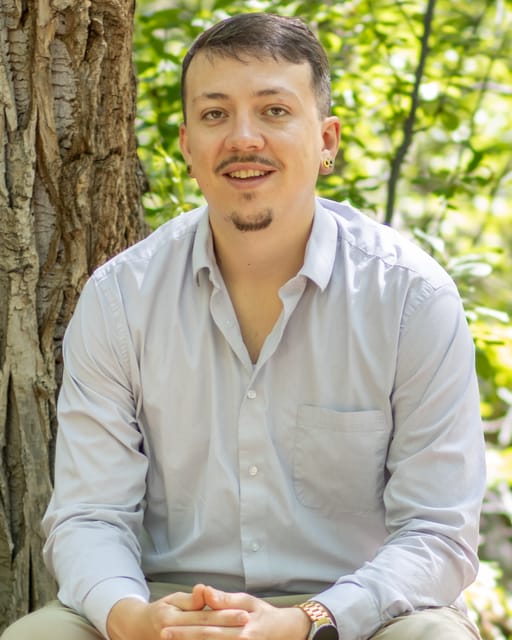 Craig Martinez, sitting on a bench outdoors